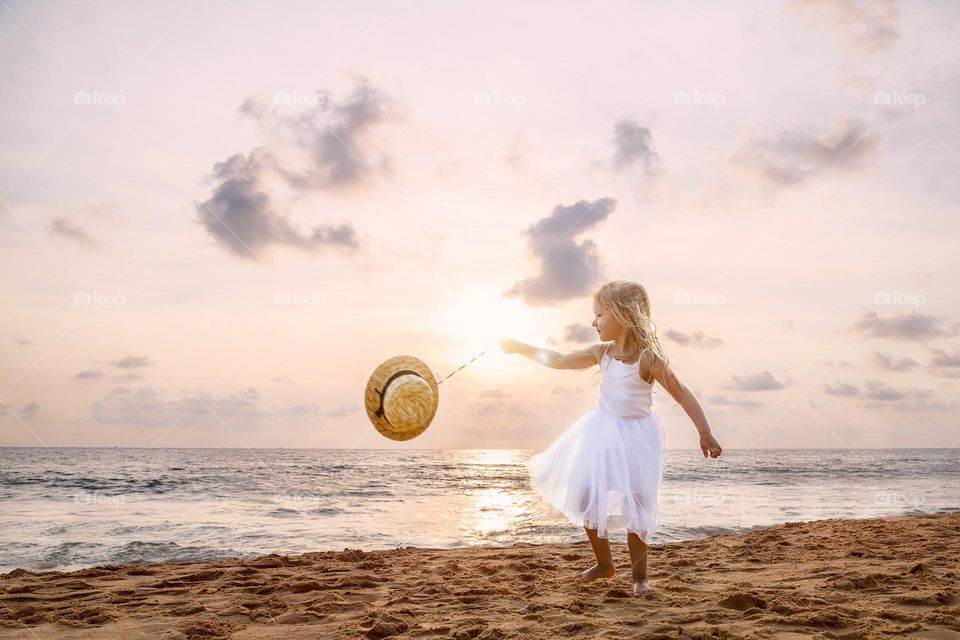 Cute little Caucasian girl having fun on the beach 