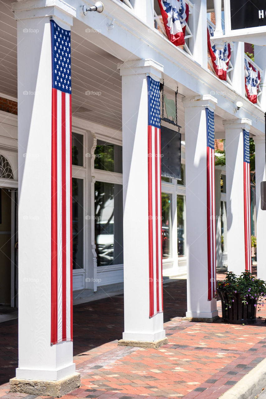 Long hanging American flags on the pillars of a historical building