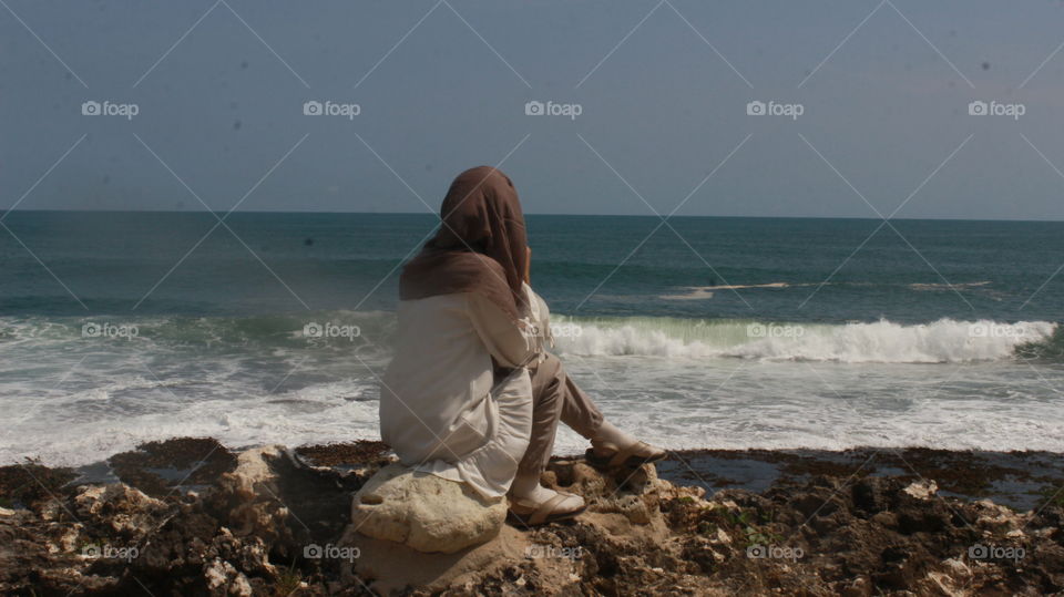 the woman sitting on the beach, was enjoying the beach atmosphere