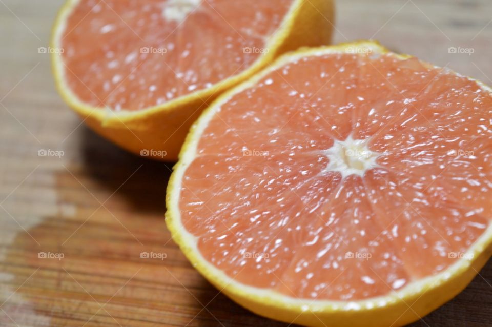 Grapefruit sliced in half on a wooden background 