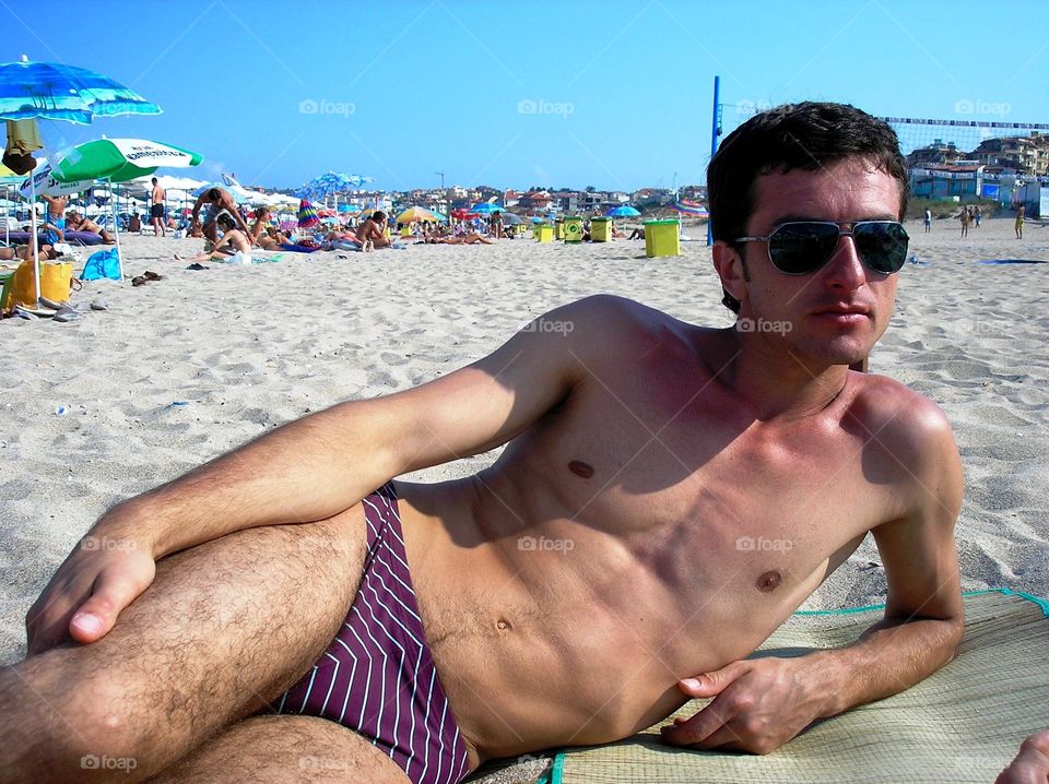 Young man lying on the beach