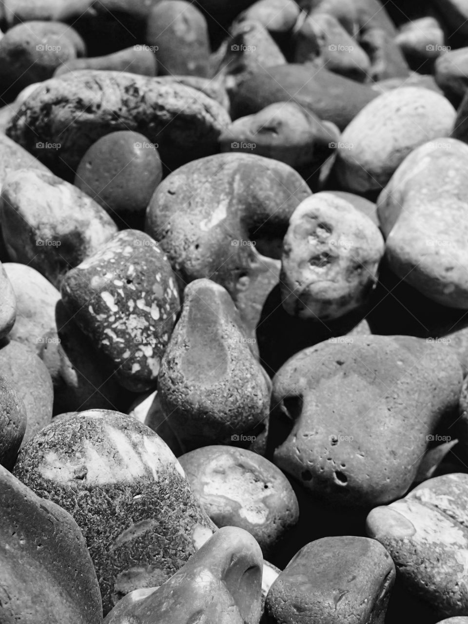 A closeup of the smooth texture of rocks on a beach