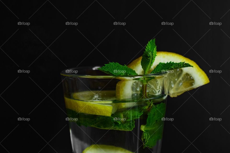 Yellows and green, water with lemon and mint, low key, still life