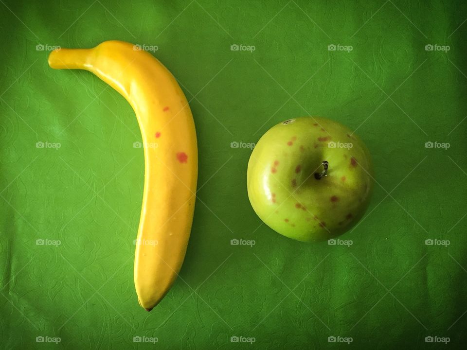 Fruta número dez. Banana e maçã em fundo verde