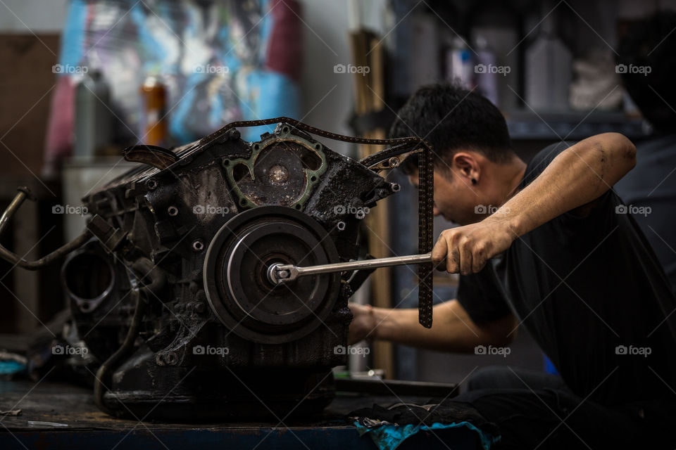 Technician fixing the car engine in the garage 