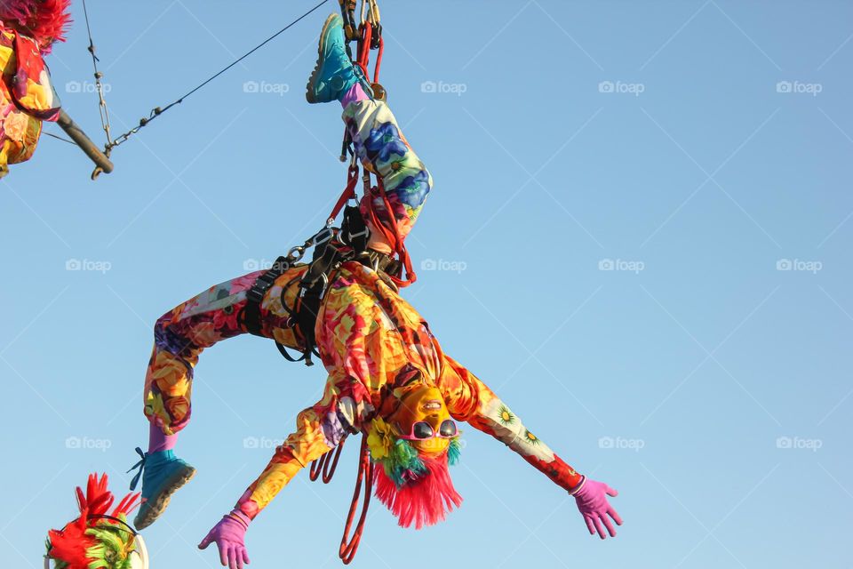 The girl upside down in the air hanging on the rope is performed by an acrobatic trick