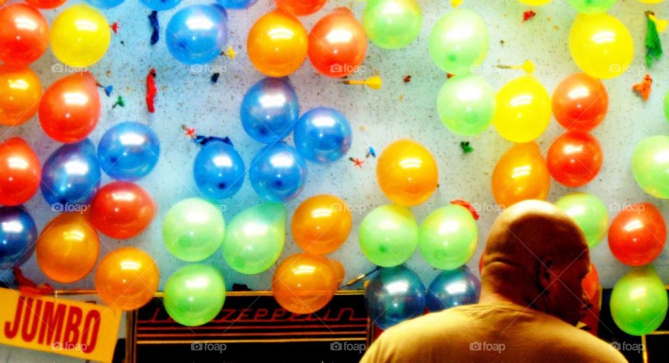 Step right up. A bald man with colorful balloons at the state fair in Vermont