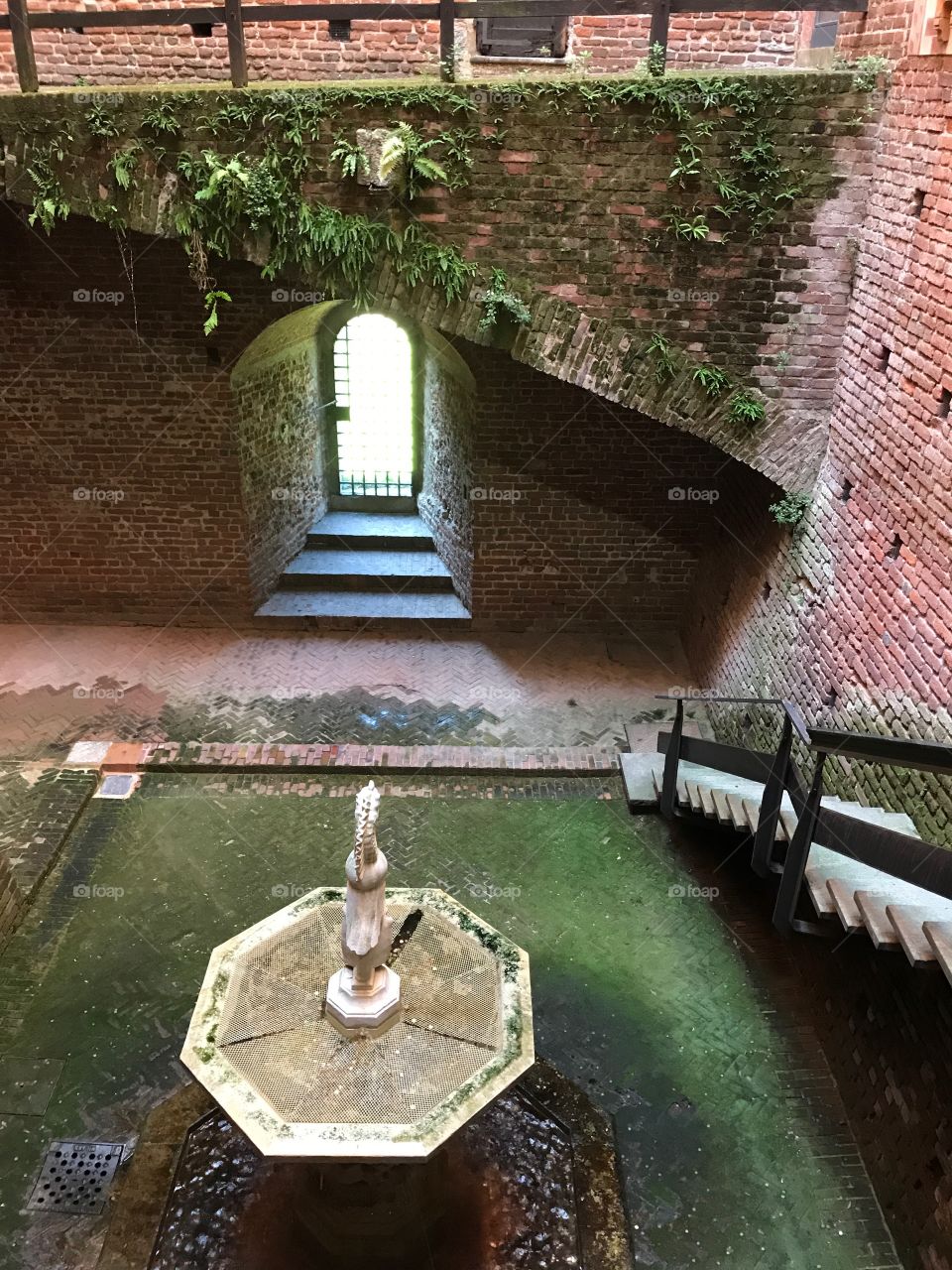 Cooling garden between buildings with water fountains in Castle of Milan