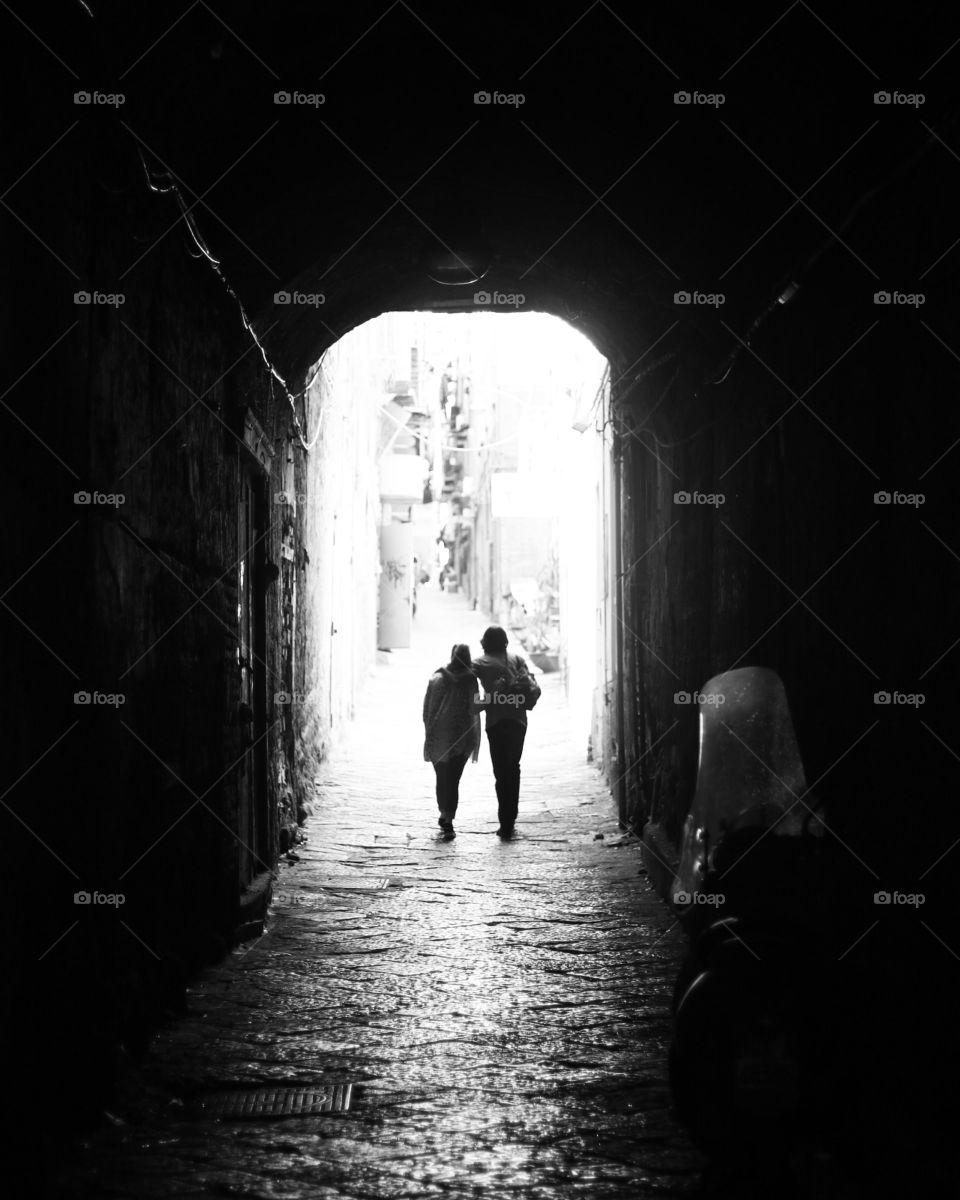 A picture of two people crossing a dark tunnel.
