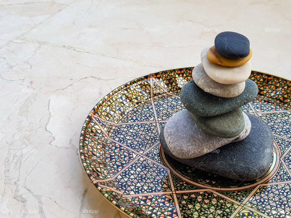 colourful pebbles arranged balancing on a beautiful plate