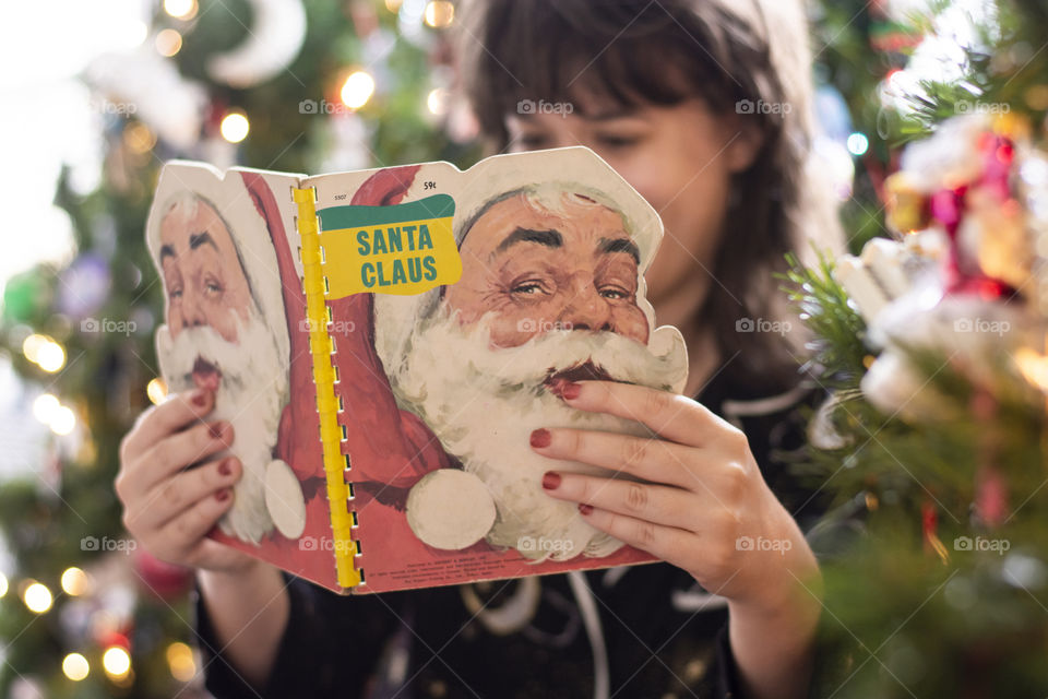 Reading traditional Christmas books are classic holiday activities for the winter season by the lights and trees