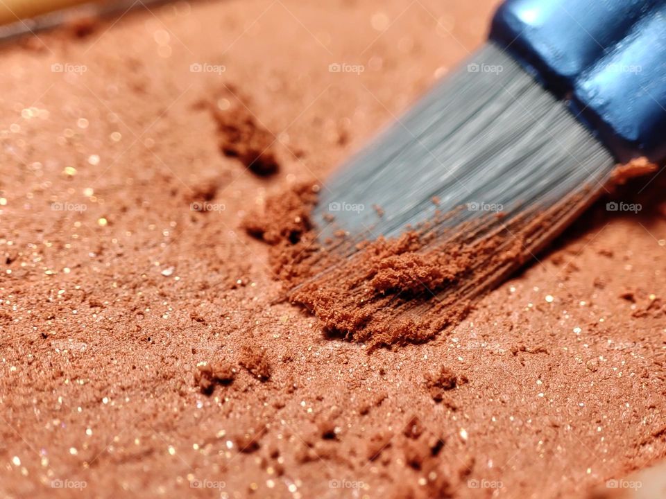 Macro photo of an eyeshadow / Makeup pallet / Beauty products / Close up photo of makeup / Makeup brush dipped in eyeshadow / Glittery orange eyeshadow