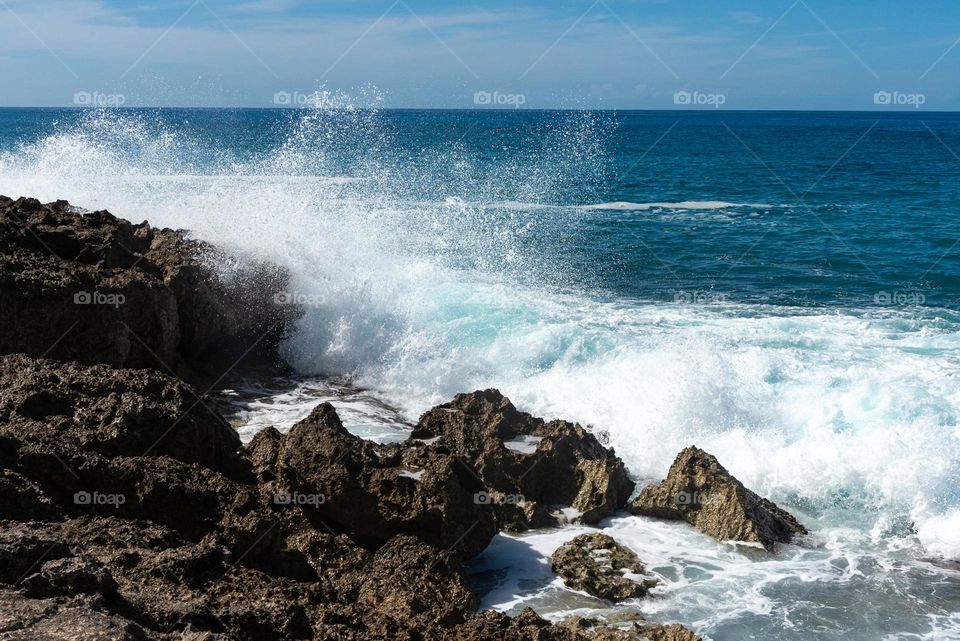 Waves crashing on black coral coastline in Ohau Hawaii