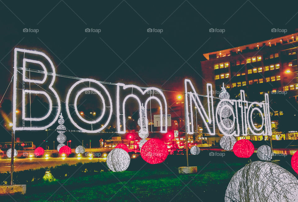 Huge red & white, lit up merry Christmas sign and decorations on a large roundabout in Lisbon, Portugal 2019