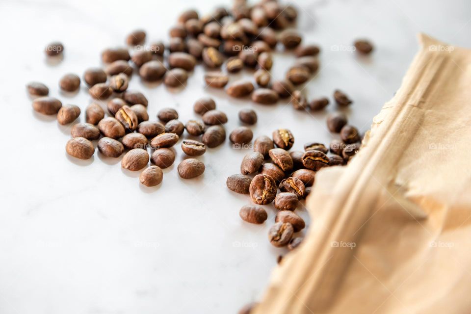 Roasted coffee beans spilled out of paper bag