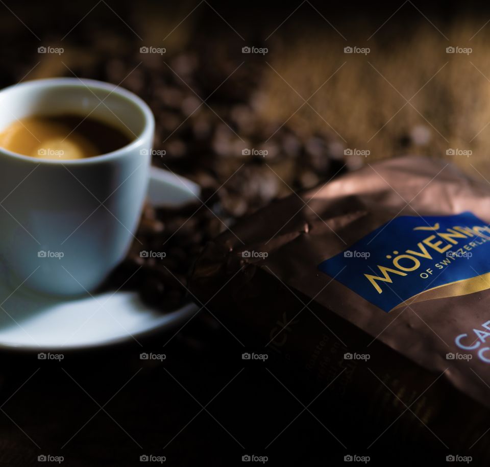 Mövenpick coffee. Cup of coffee and coffee beans spilled everywhere from the coffee bag