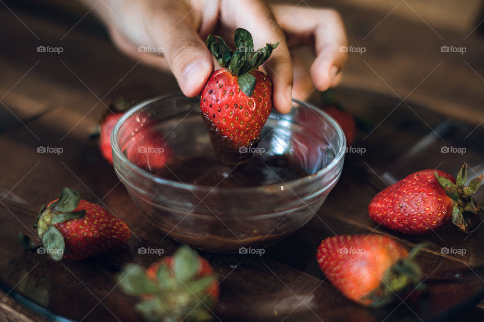 Enjoying a craving, eating strawberries with delicious chocolate