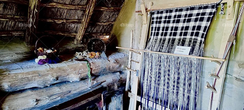 This is a window with curtains, a shelf with rolled up rugs and a tray with small potteries at the “Keltendorf Gabreta”, a newly erected Celtic village near the small town of “Ringelai” in “Bavaria”, Germany. 2023. Hypnotic Productions