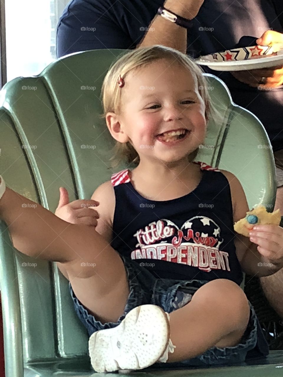 Little miss independent toddler girl eating cookie on the 4th of July