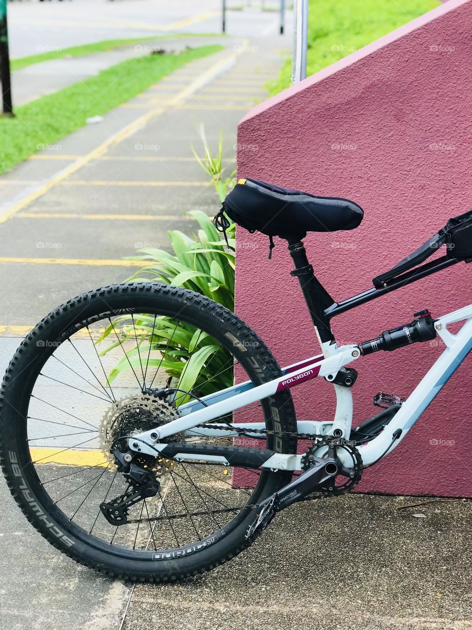 A black colour bicycle stands in front of the pink wall looks pretty beautiful 😍