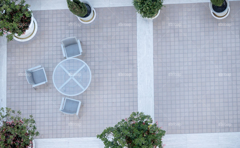 A tranquil rooftop garden with patio table and chairs.  