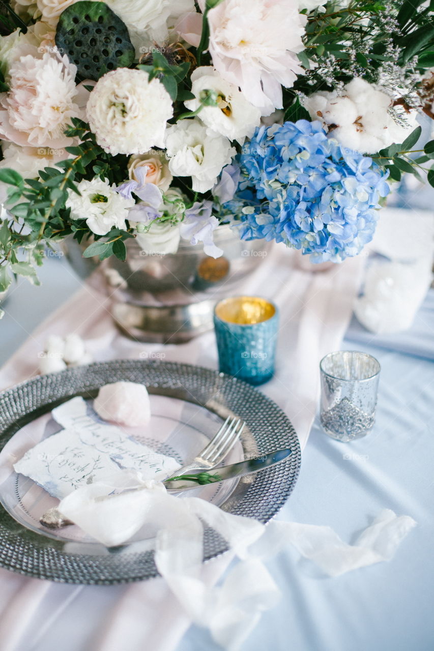 Graphic arts of beautiful wedding calligraphy cards and silver plate with cutlery on festive wedding table.