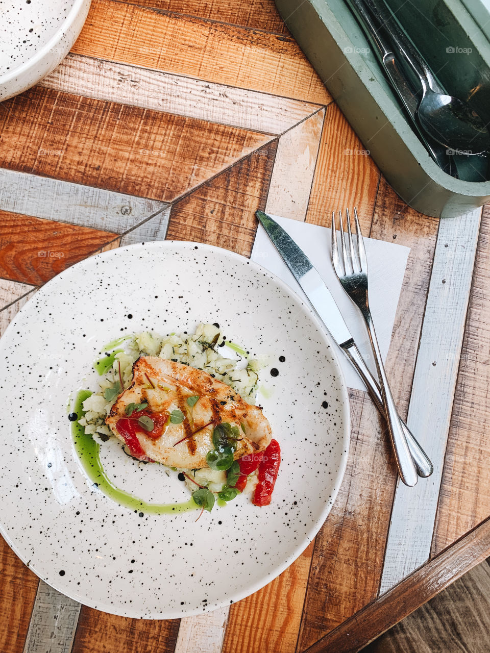 Stuffed squid with vegetables on plate on table in cafe, top view 