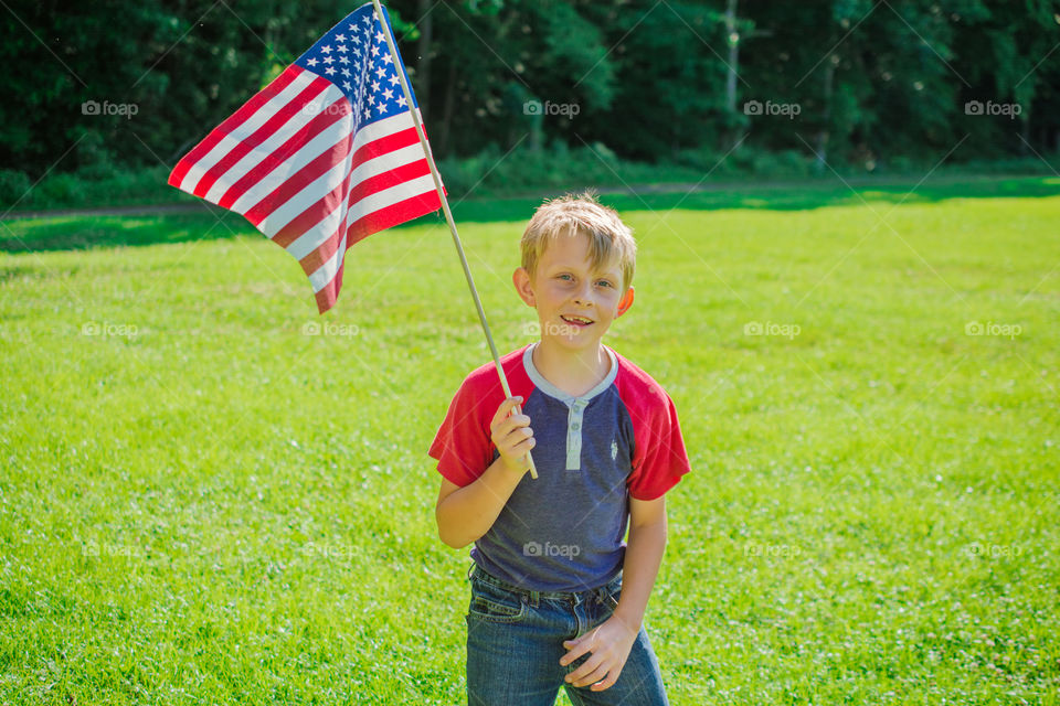 Young Boy Standing with American Flag