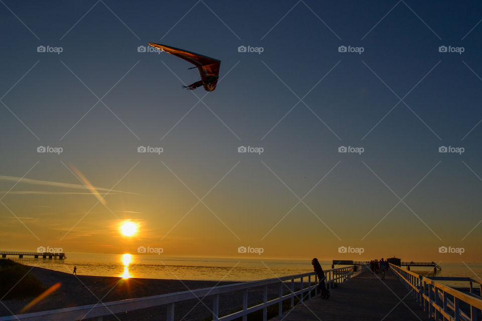 Kite flyer over Ribban beach at sunset in Malmö Sweden.