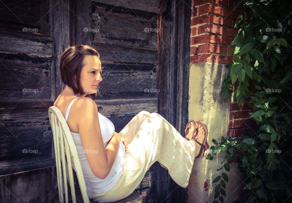 Woman sitting beside wooden door