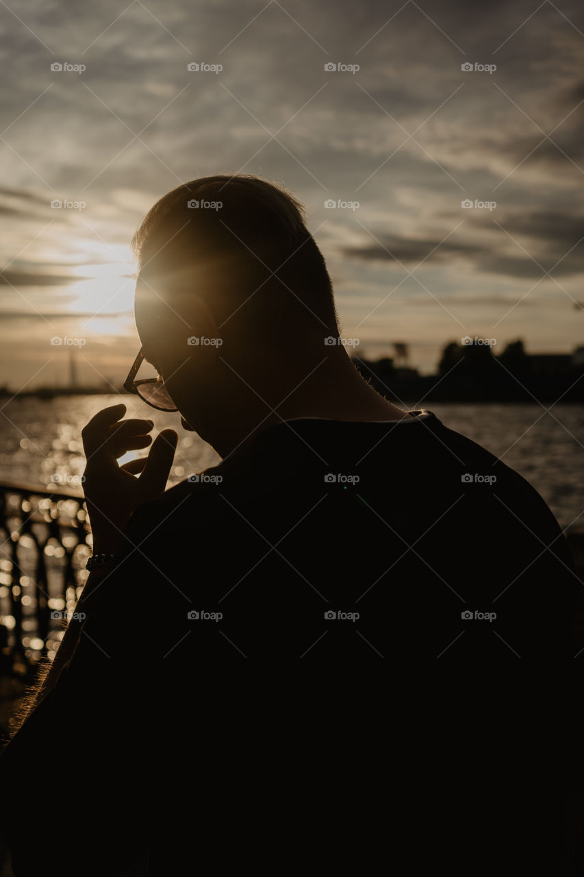 silhouette of a man wearing sunglasses in sunset light