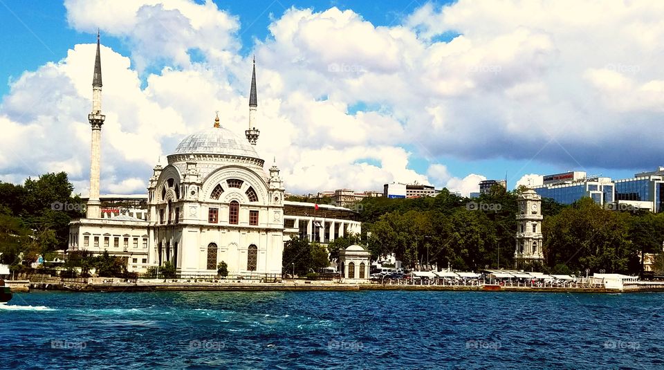 a mosque and clock tower on the coast of Istanbul Turkey