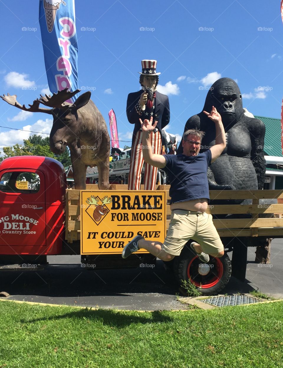 Crazy dad clowning around by giant roadside statues