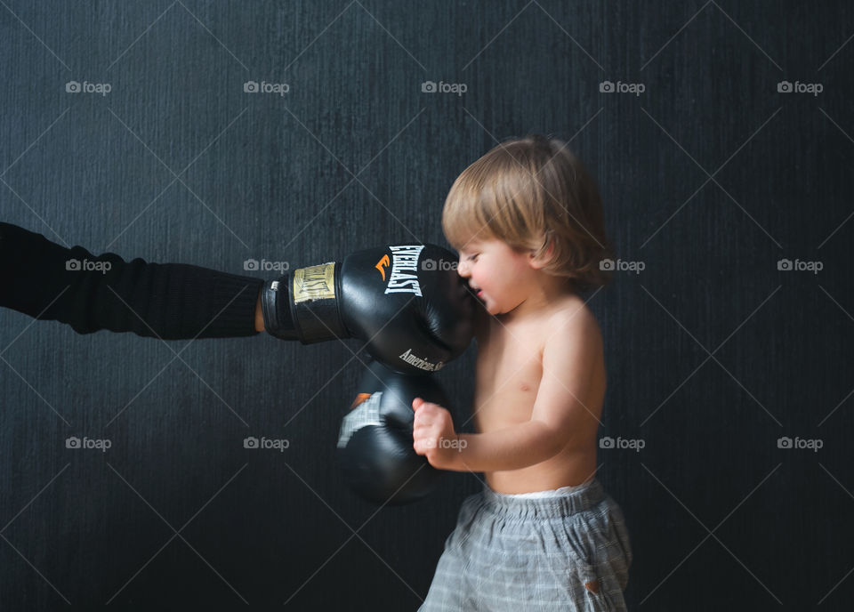 little athlete.  boy in red boxing gloves stands in sparring