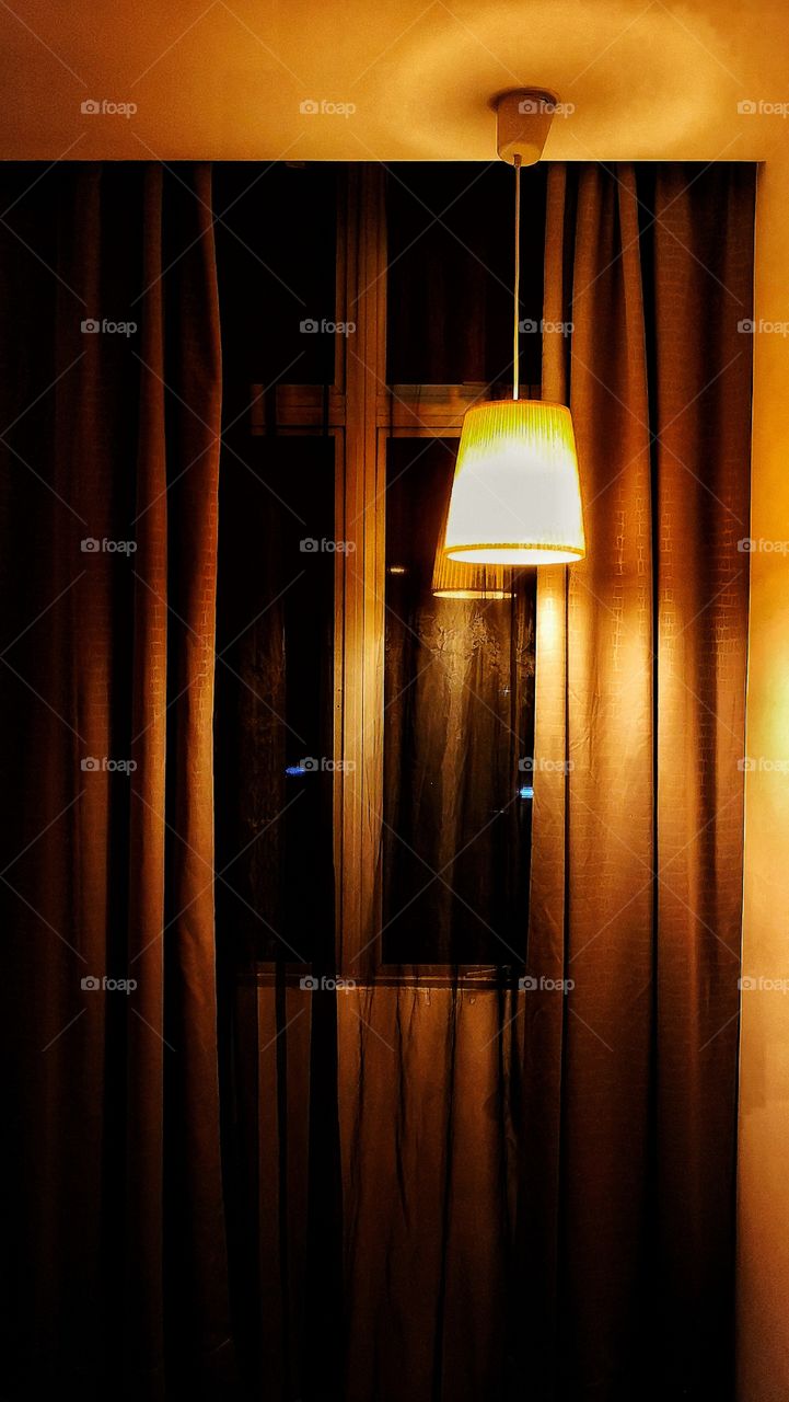 Warm light in a room next to window with curtains