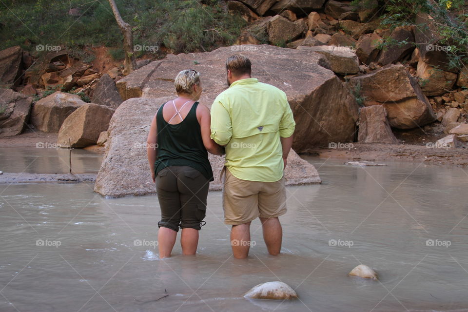 Couple wading in stream