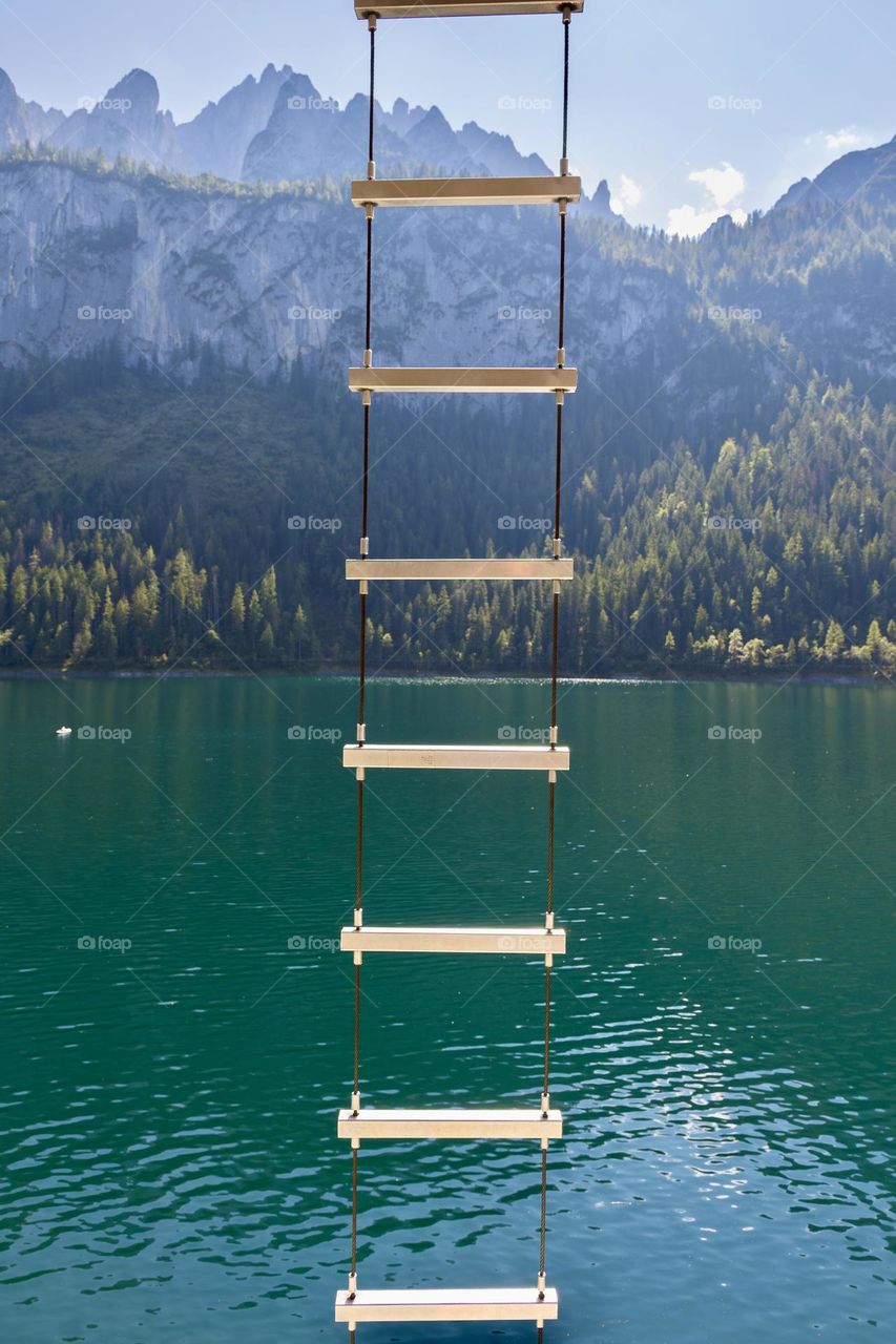 Ladder by the lake with mountains in the background 