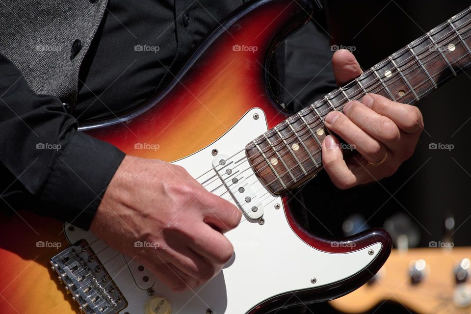 Man playing aged vintage electric guitar.