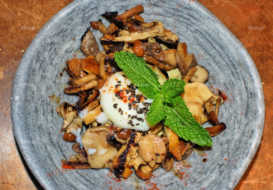 Bowl of mushrooms and fungi with an egg cooked at low temperature