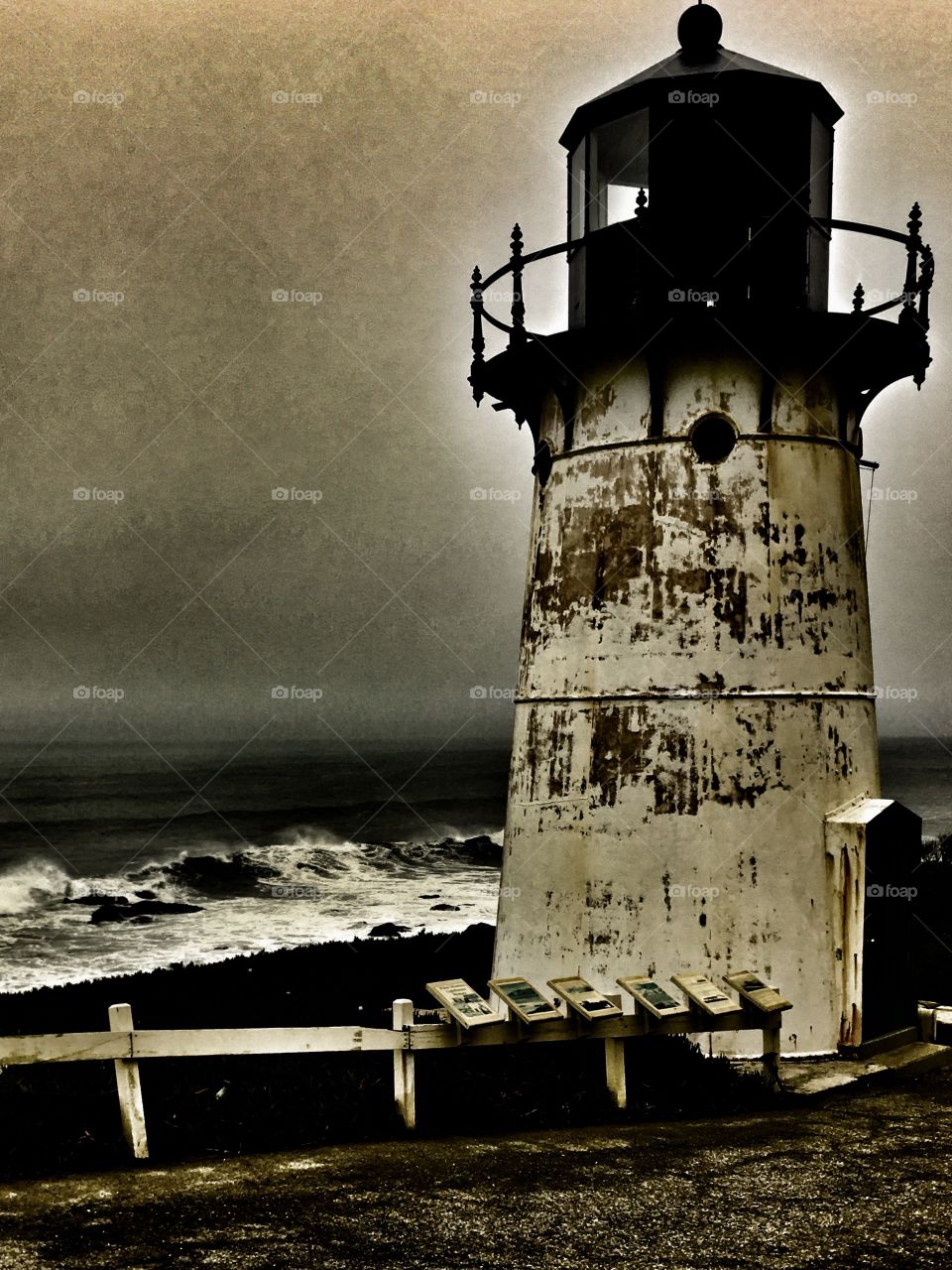 Stormy seas and a lighthouse all in black and white. 