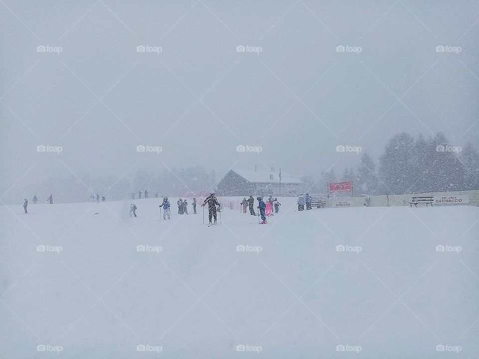 Life in motion. Snowy ski run. People on skis. Dolomites Mountains of Val di Fassa. Snowfall