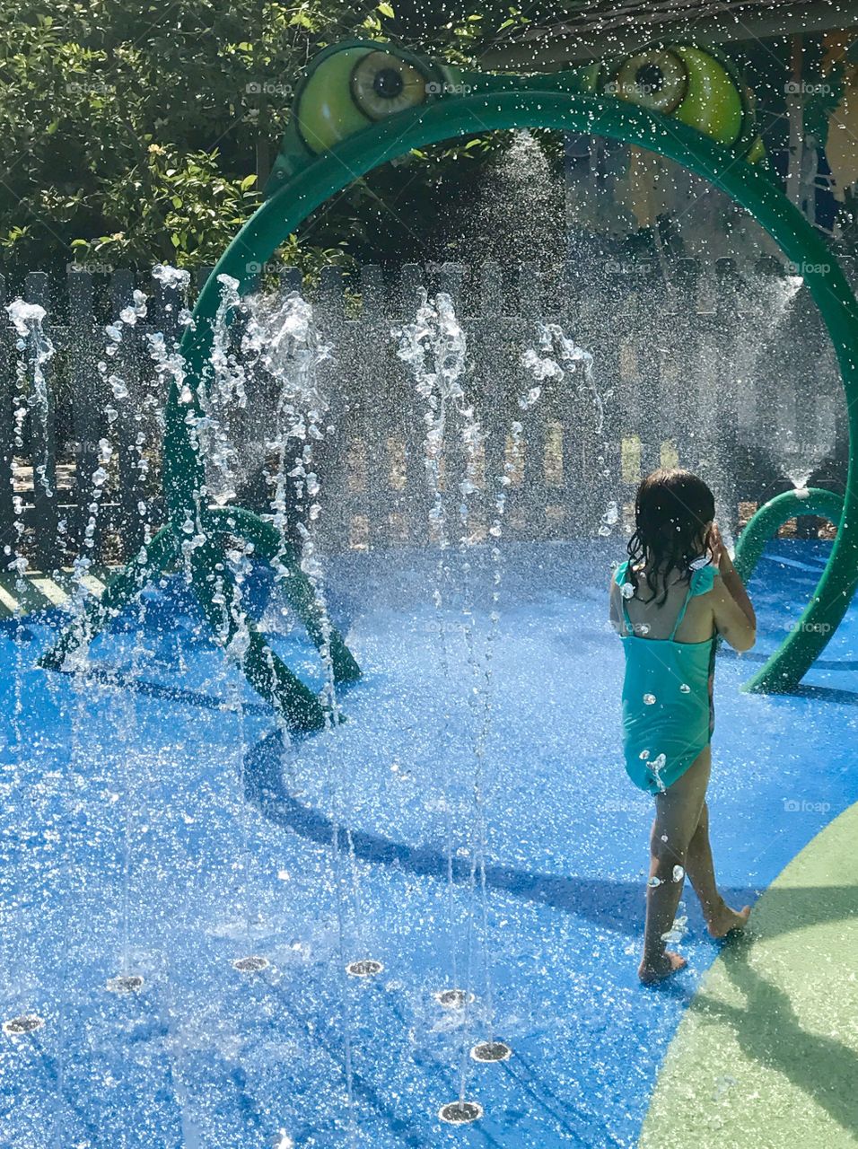 Young girl walking through fountains