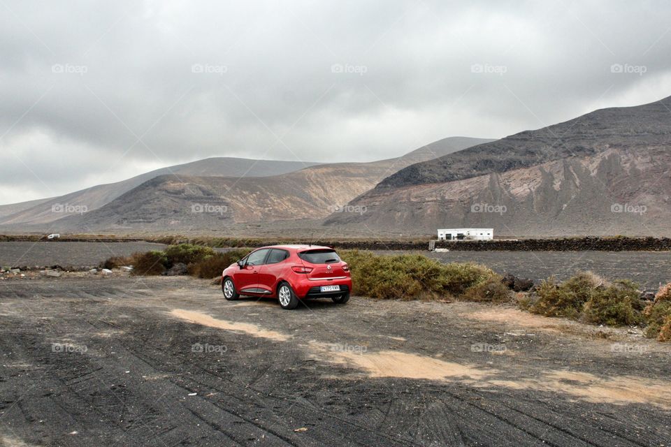 Red Car taking in a stunning view in Orzola, Lanzarote.