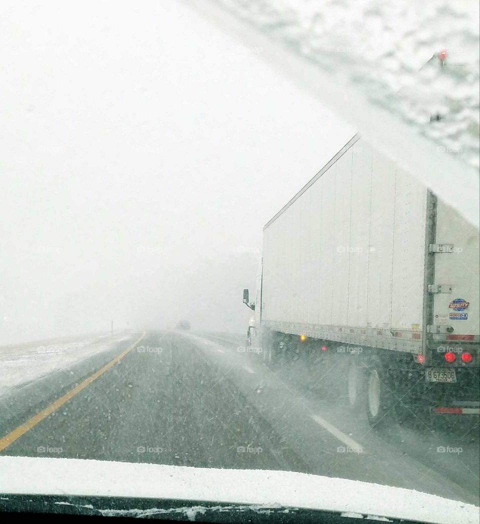 Highway blizzard passing big rig.