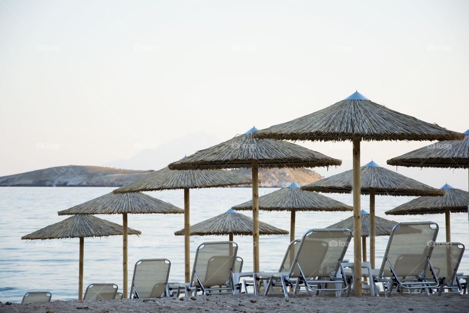 beach at sunset. deck chairs and umbrellas on the beach at sunset