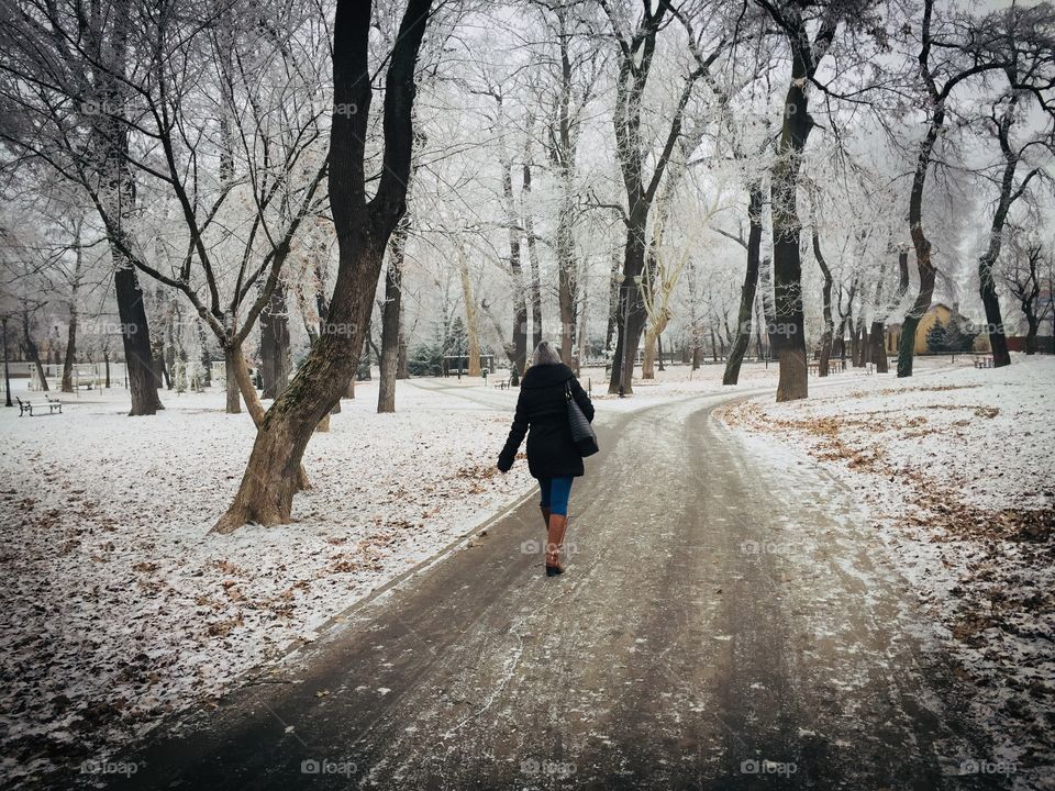 Woman walking alone in the park in winter