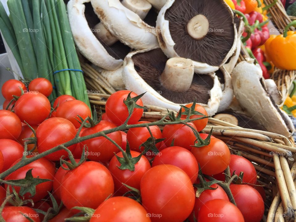 A basket full of fresh organic vegetables on an outdoor market stall 