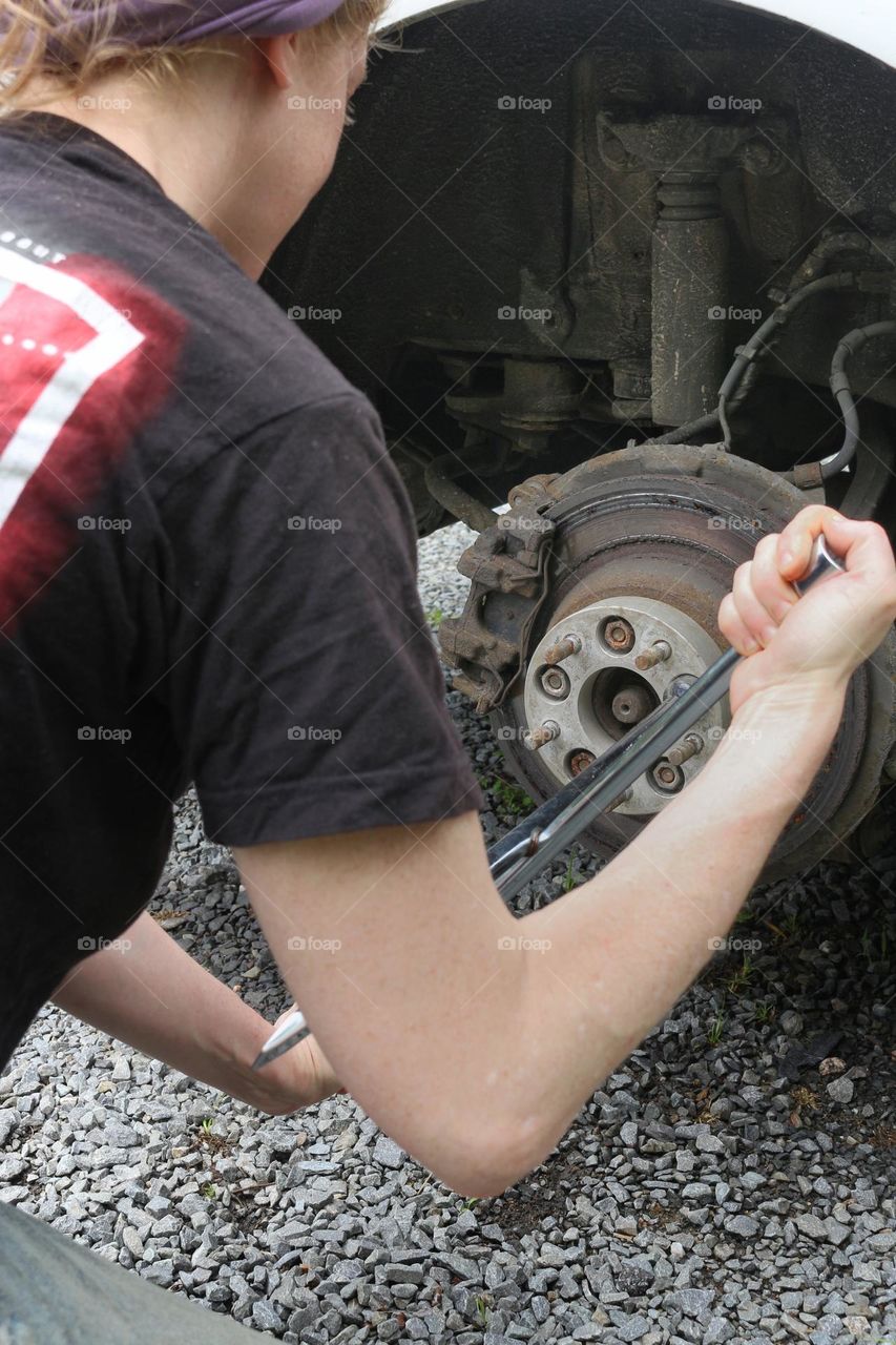 Loosening the lug nuts from a wheel adapter to change a tire.