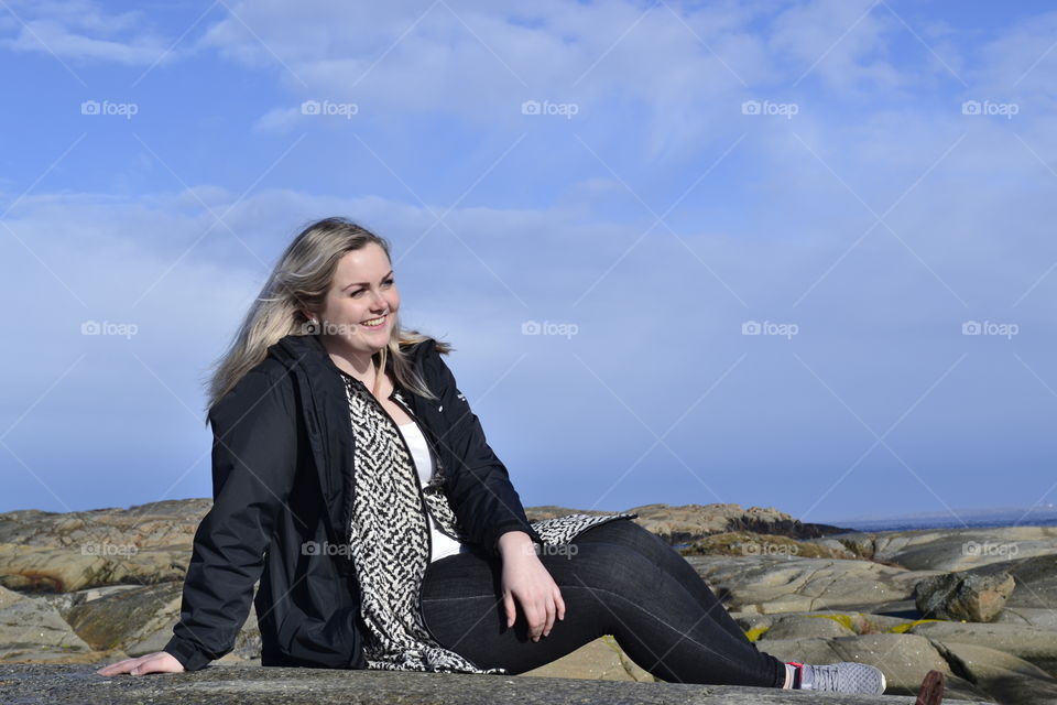 Smiling woman sitting on rock