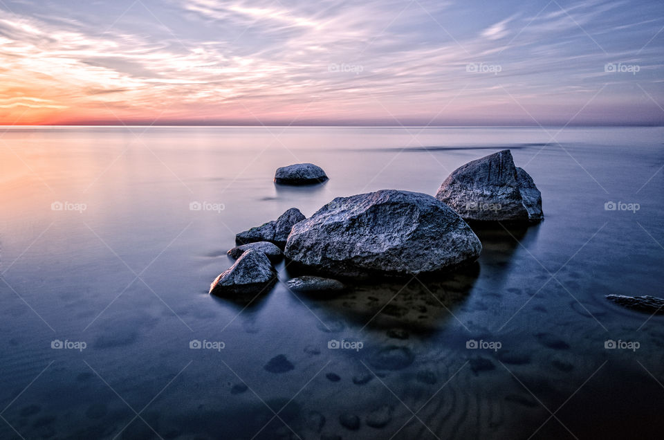 The stones in the sea at sunset. Long exposure.